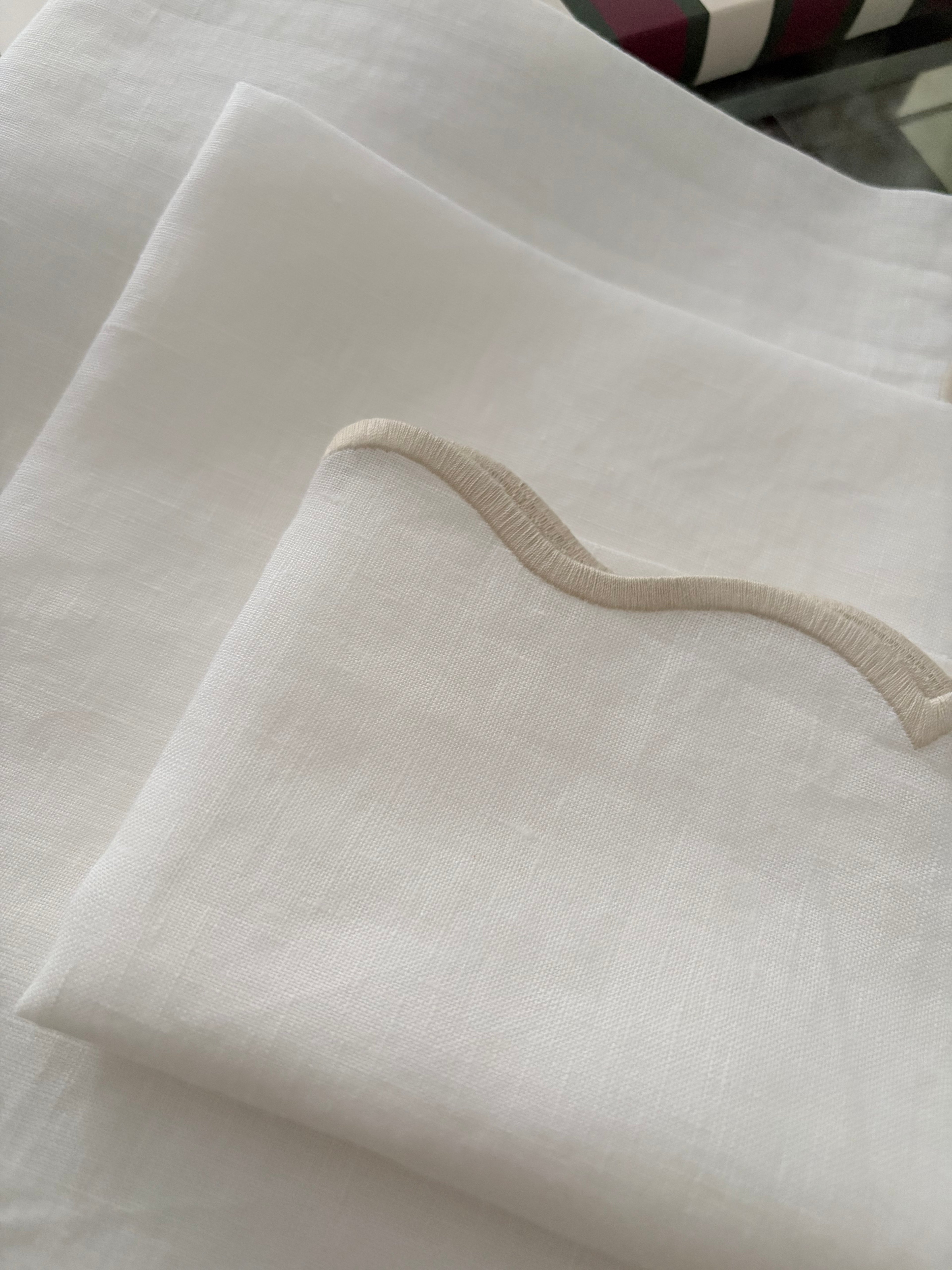 Close-up of sand-tone embroidered scalloped edge on white linen napkin | Ars Mensae