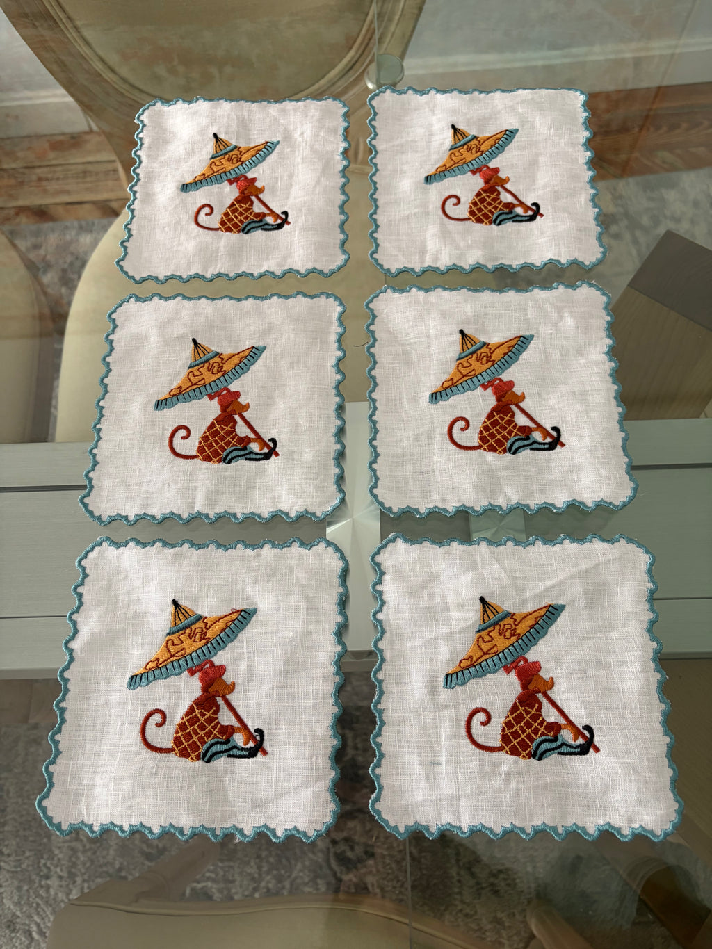 Set servilletas cóctel azul en mesa – detalle bordado parasol aperitivo elegante