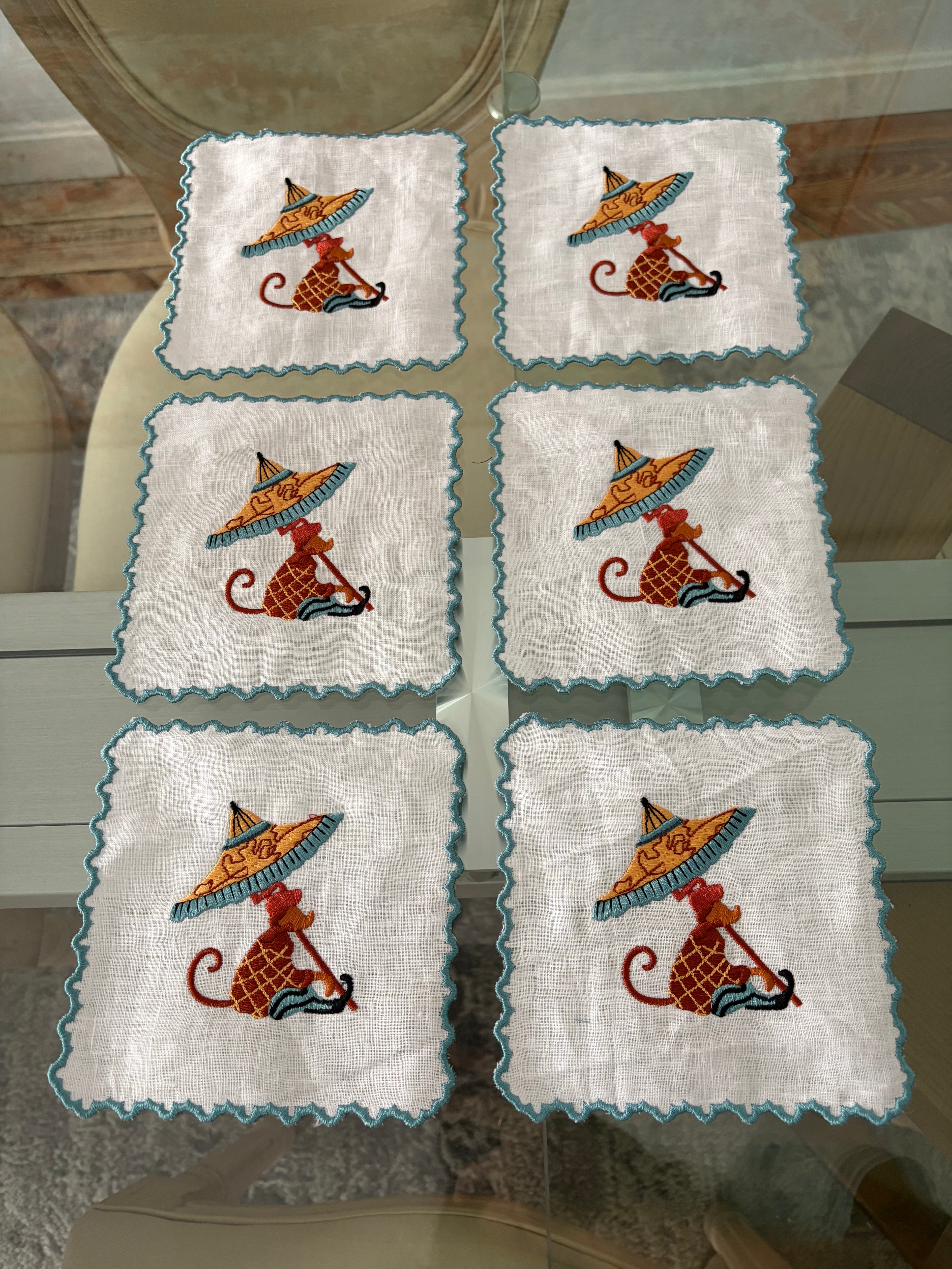 Set servilletas cóctel azul en mesa – detalle bordado parasol aperitivo elegante